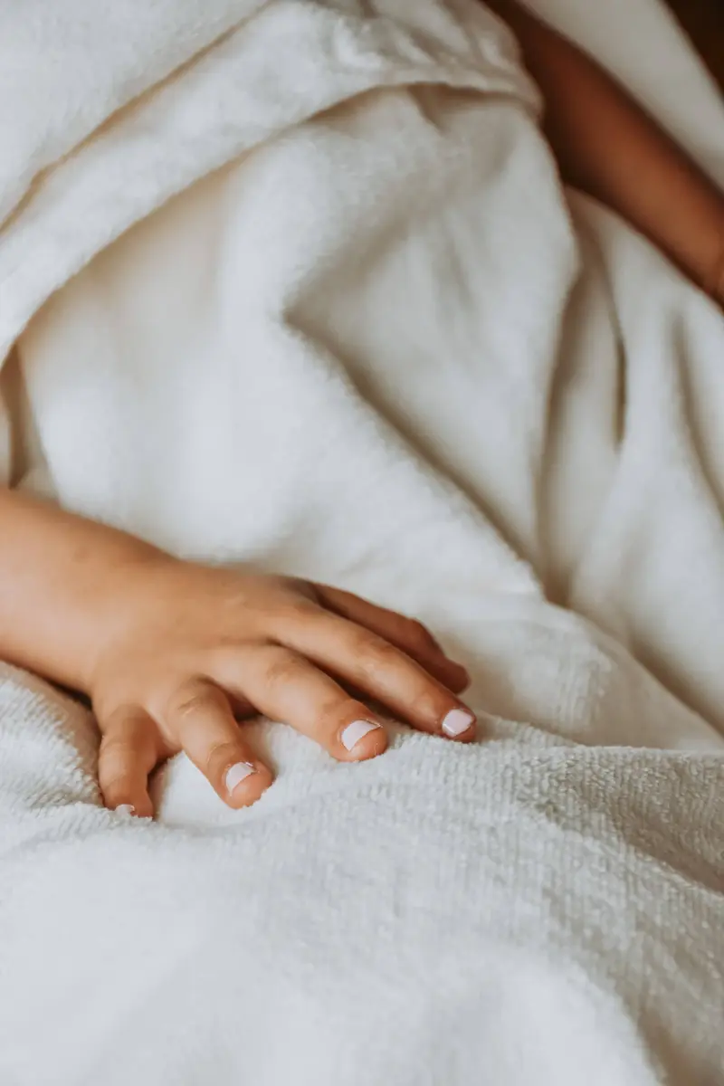 Les mains d'une enfant avec un vernis rose pastel