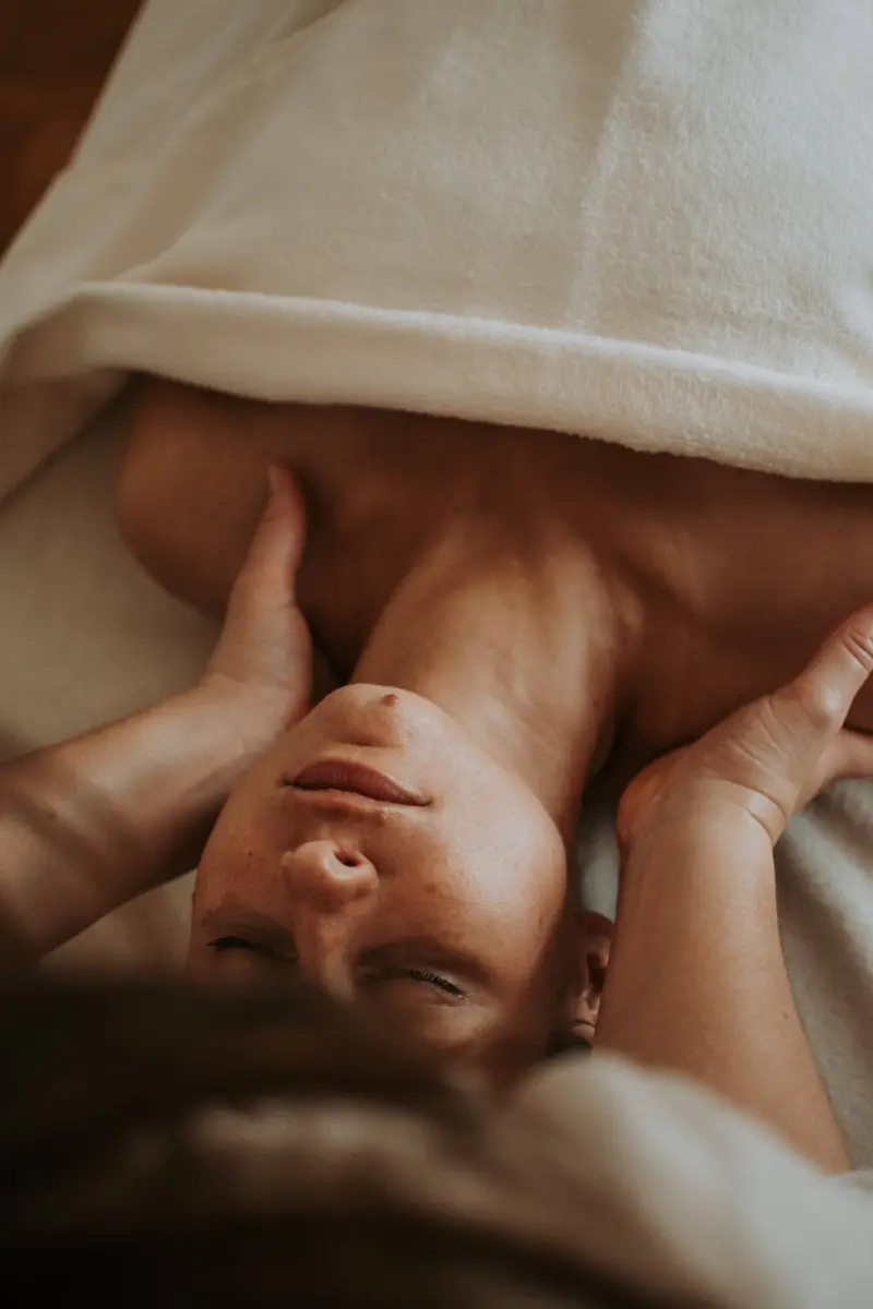 Jeune maman détendue pendant un massage post-partum
