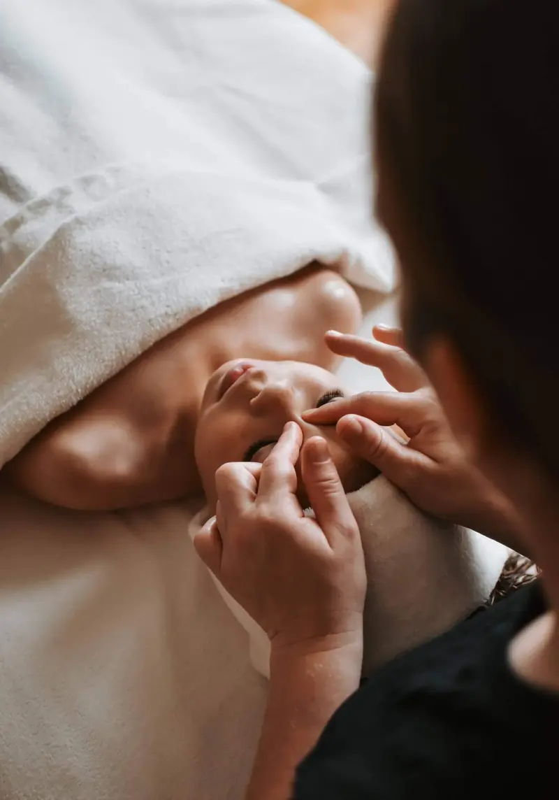 Les mains d'une maman apprennent les gestes du massage bébé
