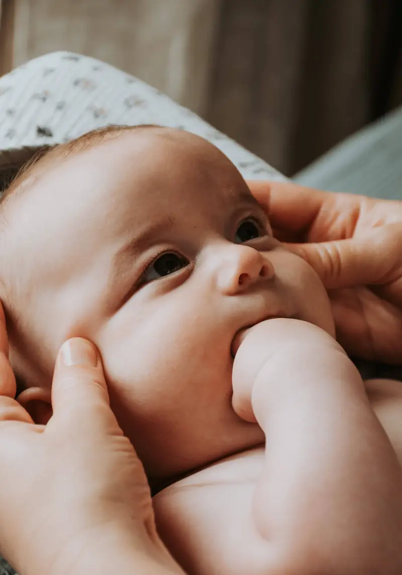 Un bébé reçoit un massage doux du visage